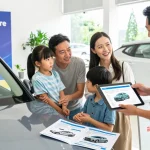 Family checking a car with reg check UK report in dealership, showcasing a trustworthy vehicle buying process.